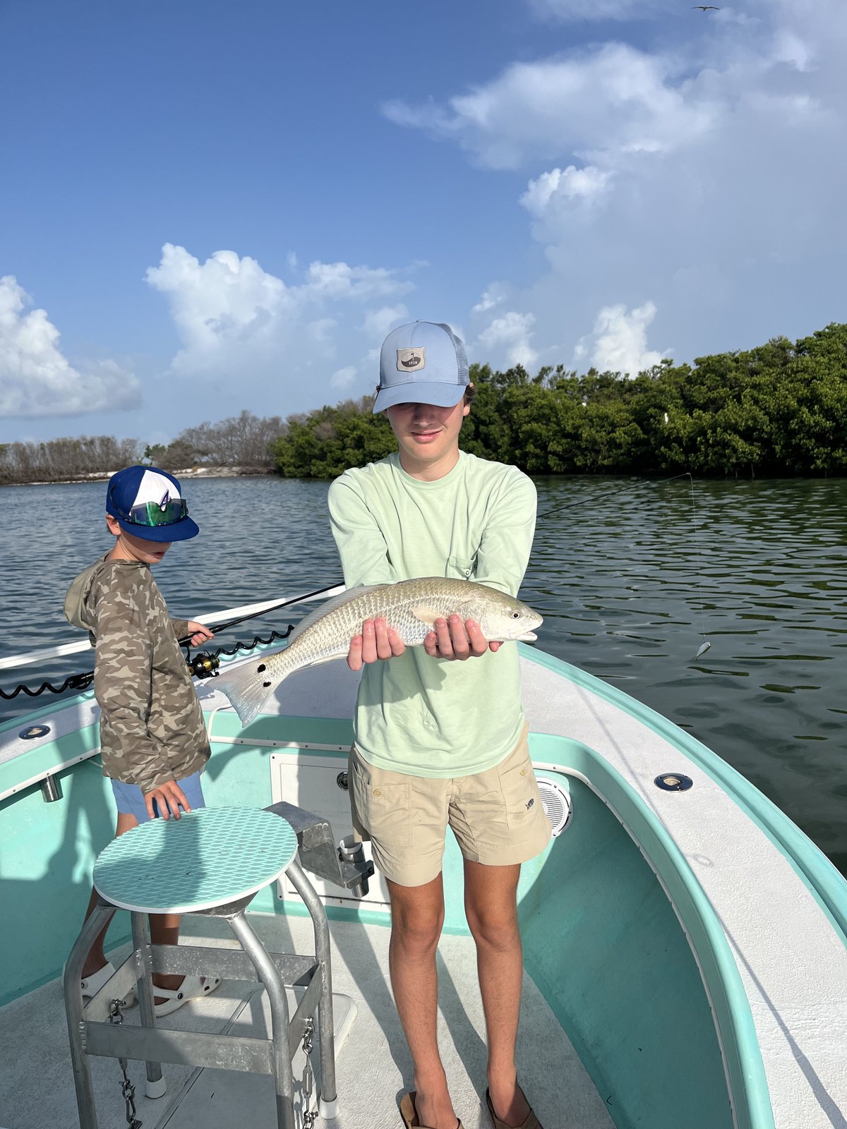 A family holding their catch on a private inshore charter
