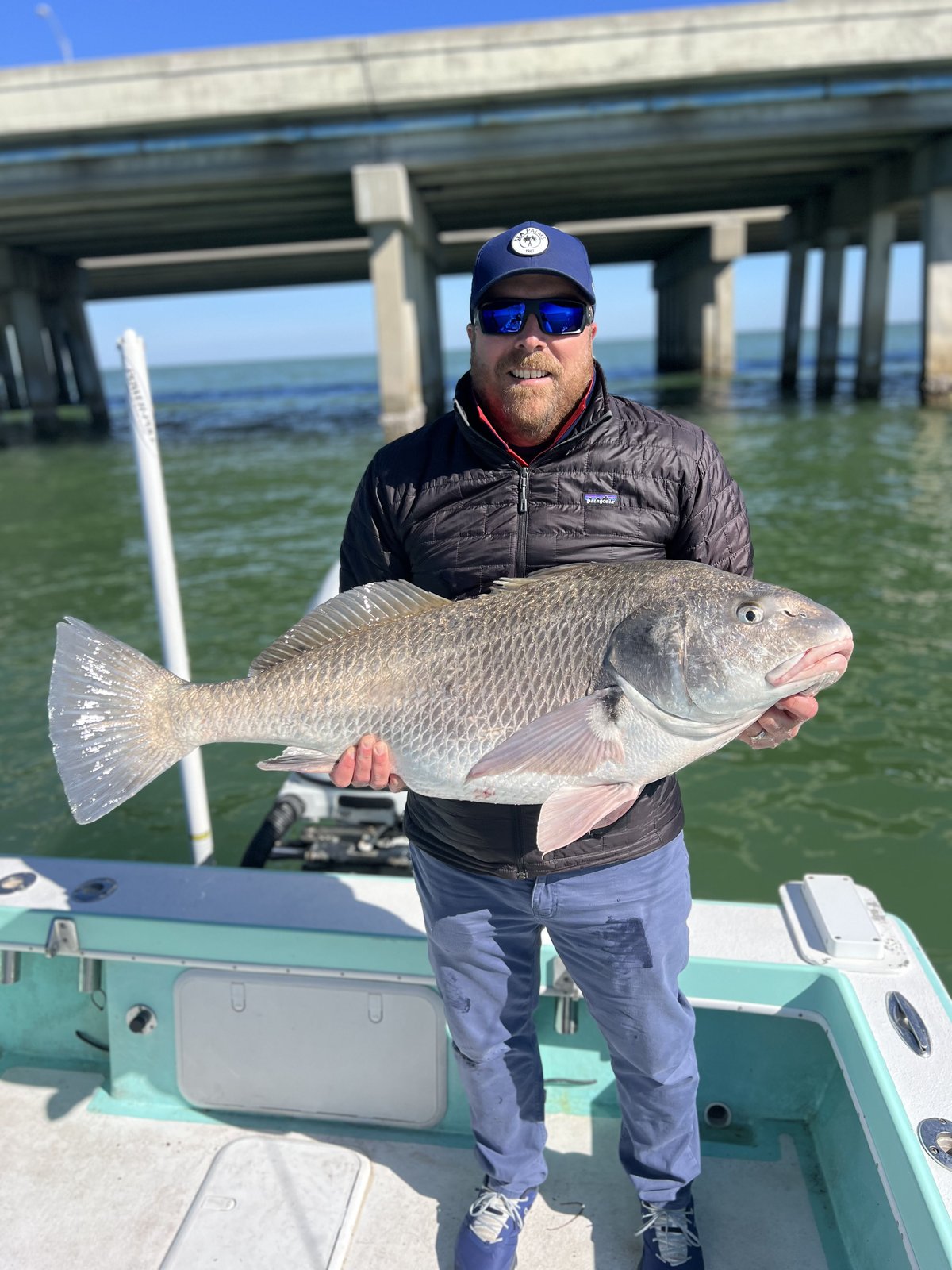 A guest holding a heavy redfish on an inshore charter