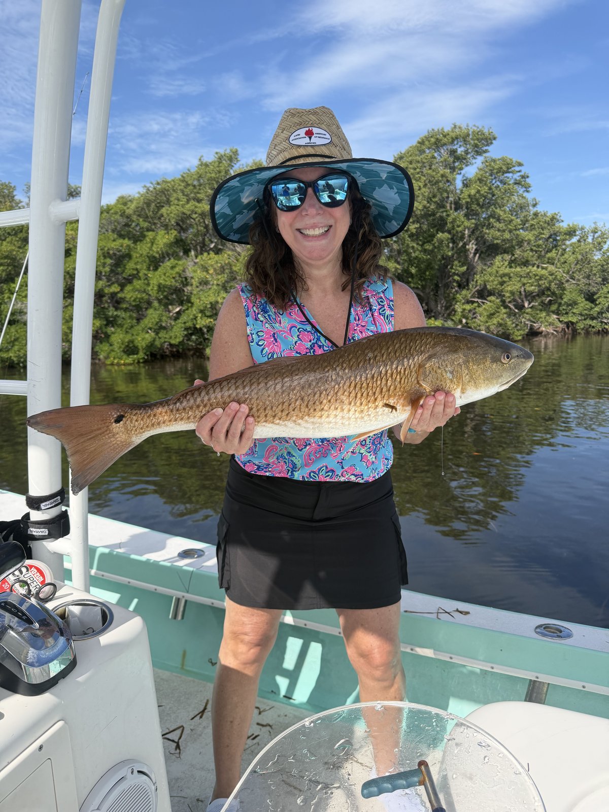 A guest holding a redfish aboard the Next Catch boat