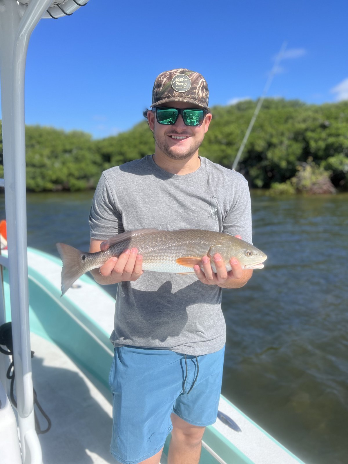 A young angler holding a redfish in Tampa Bay
