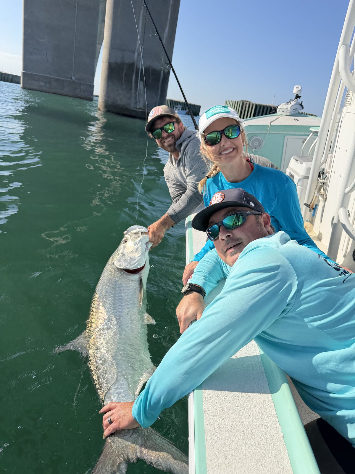 Two guests releasing a tarpon beside the boat