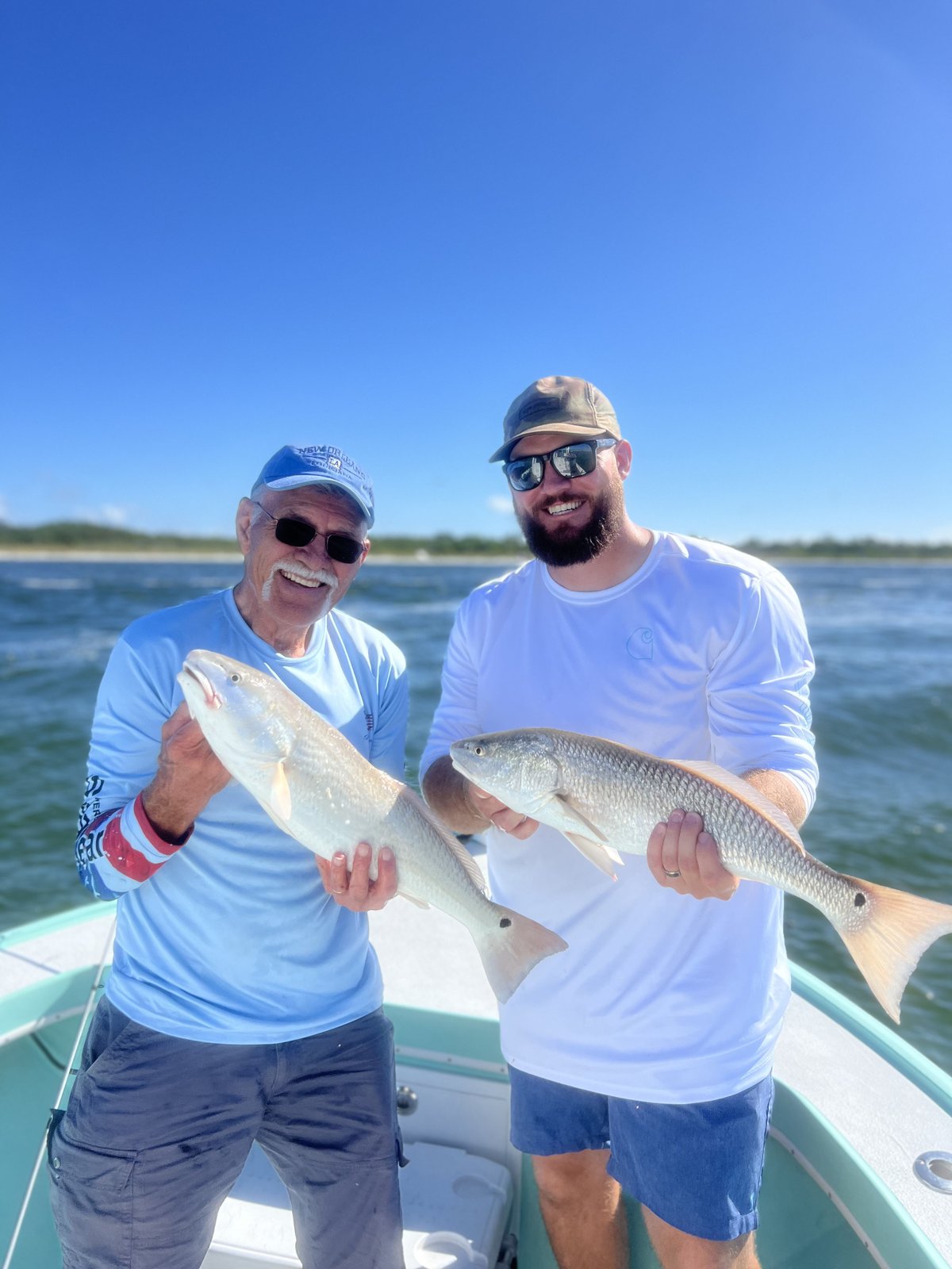 Two anglers holding a redfish in Boca Ciega Bay