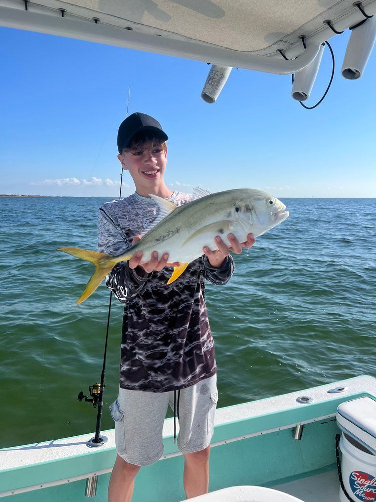 Young angler holding a jack crevalle caught on an inshore charter