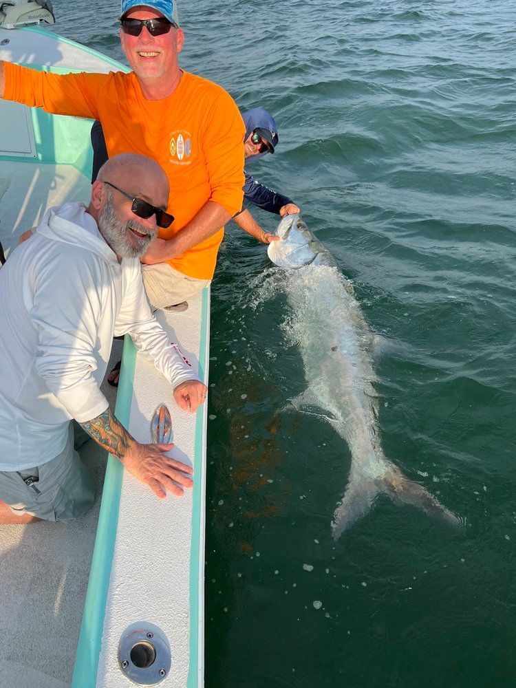 Two anglers with a tarpon boatside on a Tampa Bay charter